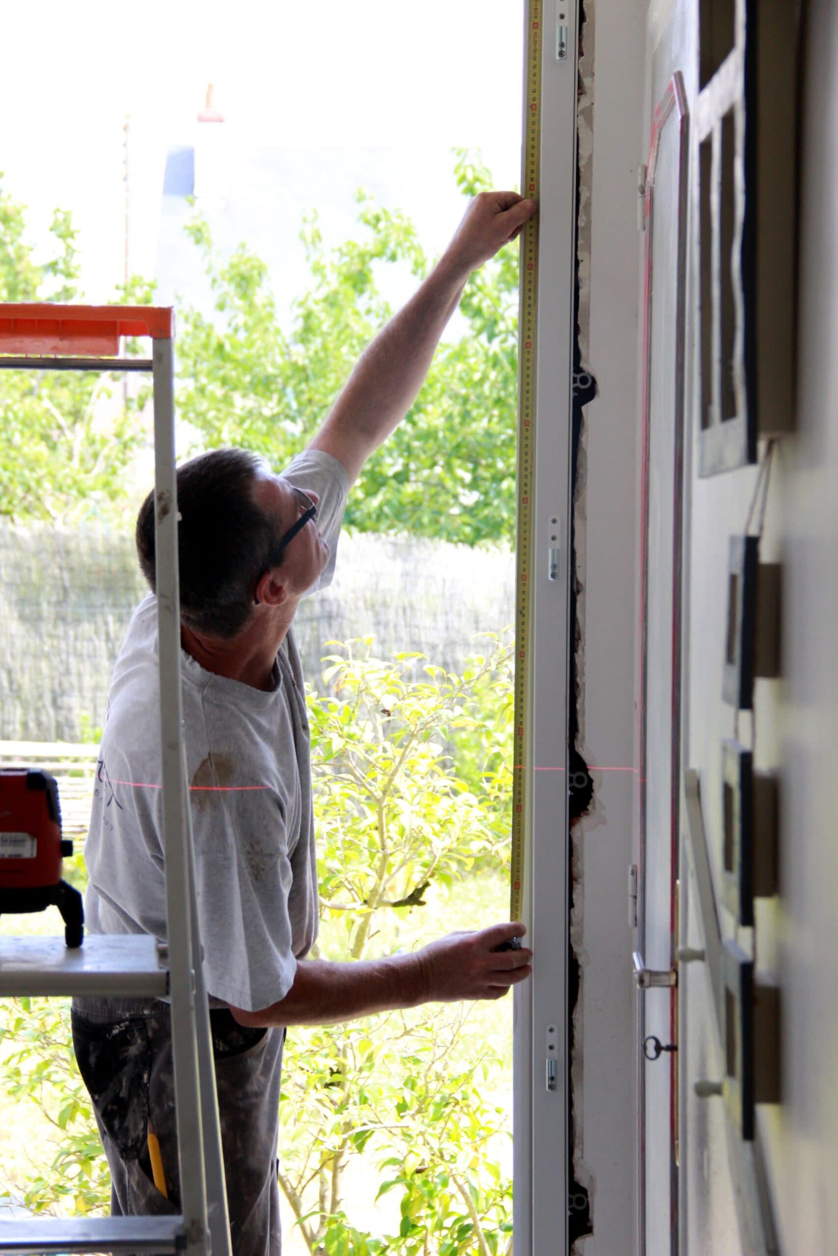 Personne prenant les mesures d'une fenêtre